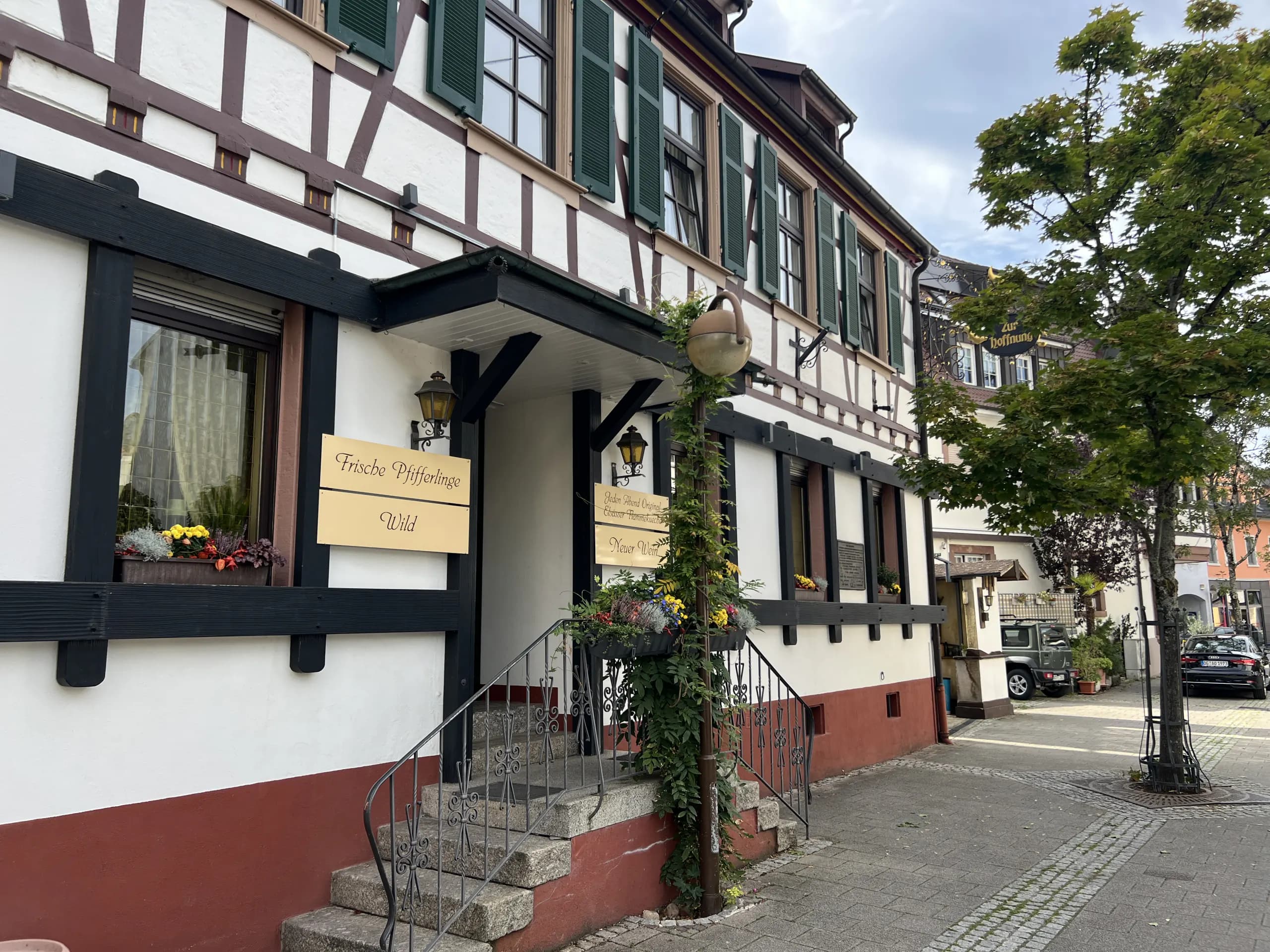 Eingang des Gasthauses Zur Hoffnung mit Fachwerkfassade und grünen Fensterläden